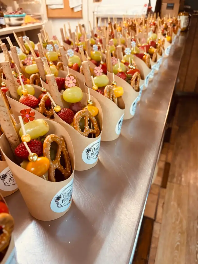 A display of mini charcuterie cups featuring meats, cheeses and various appetizers for a light snack.