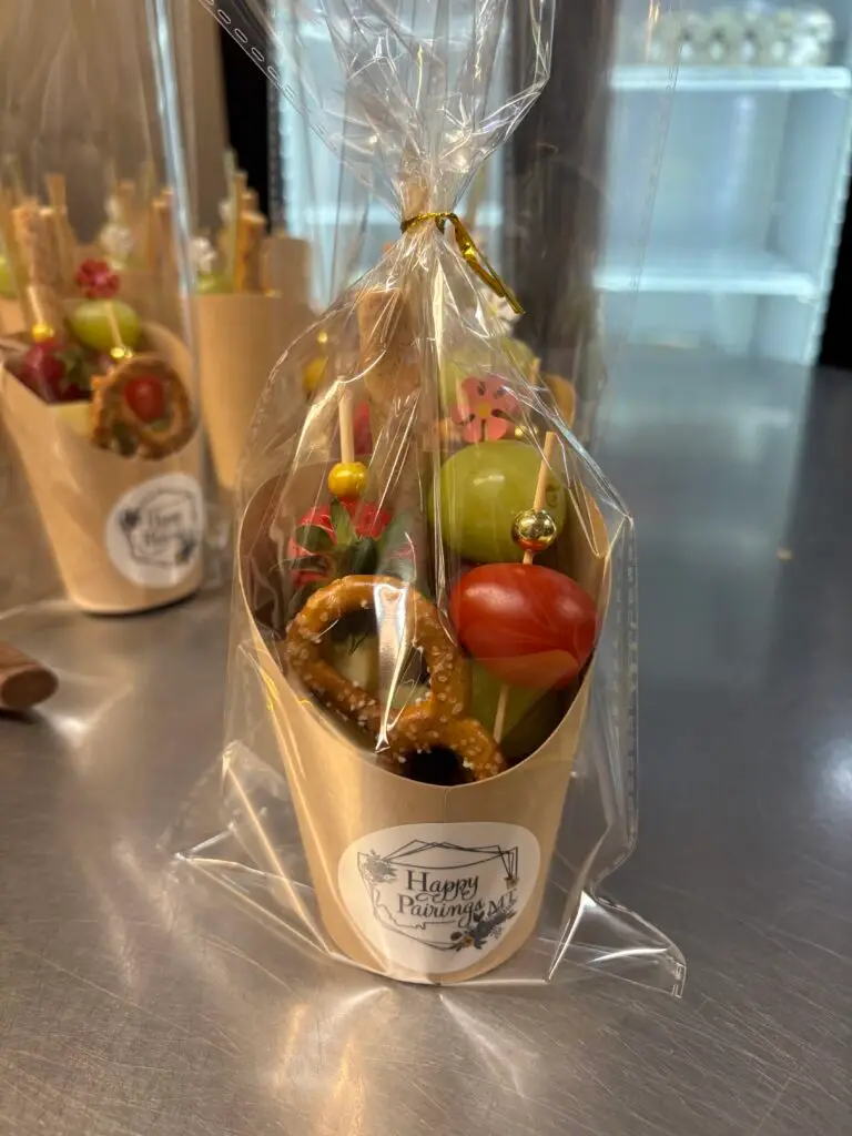 A display of mini charcuterie cups featuring meats, cheeses and various appetizers for a light snack.