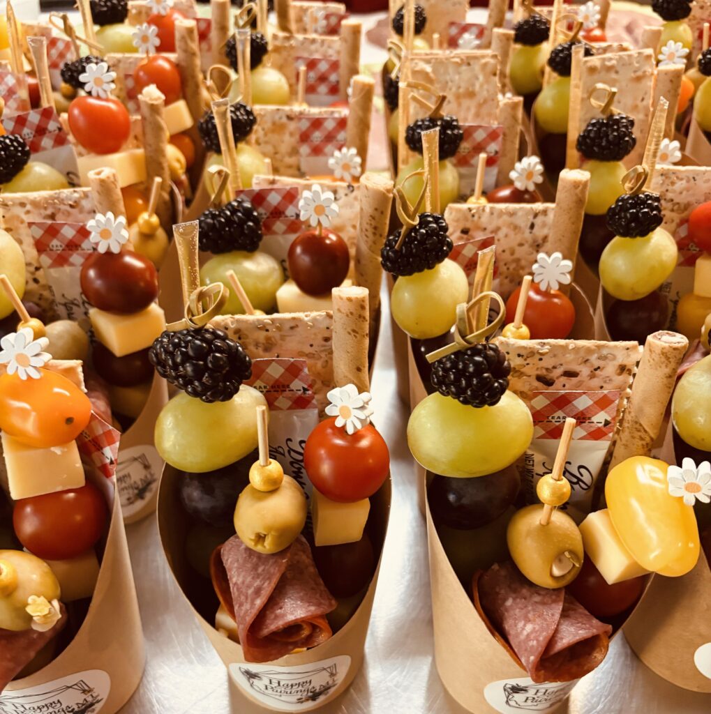 A display of mini charcuterie cups featuring meats, cheeses and various appetizers for a light snack.