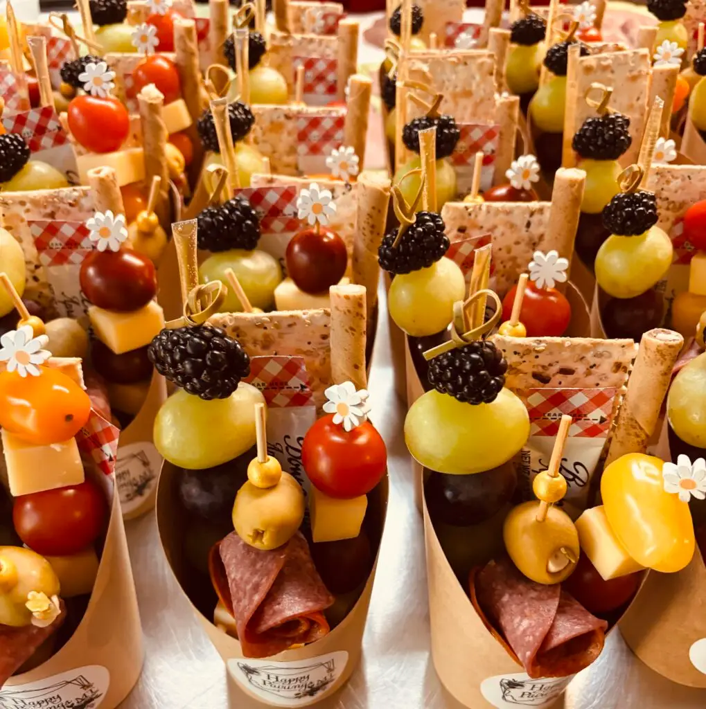A display of mini charcuterie cups featuring meats, cheeses and various appetizers for a light snack.