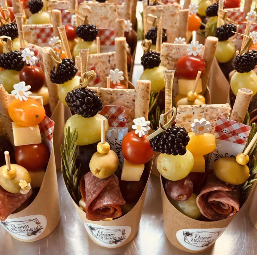 A display of mini charcuterie cups featuring meats, cheeses and various appetizers for a light snack.