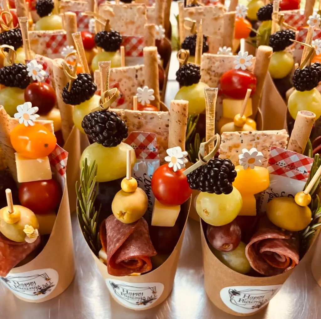 A display of mini charcuterie cups featuring meats, cheeses and various appetizers for a light snack.