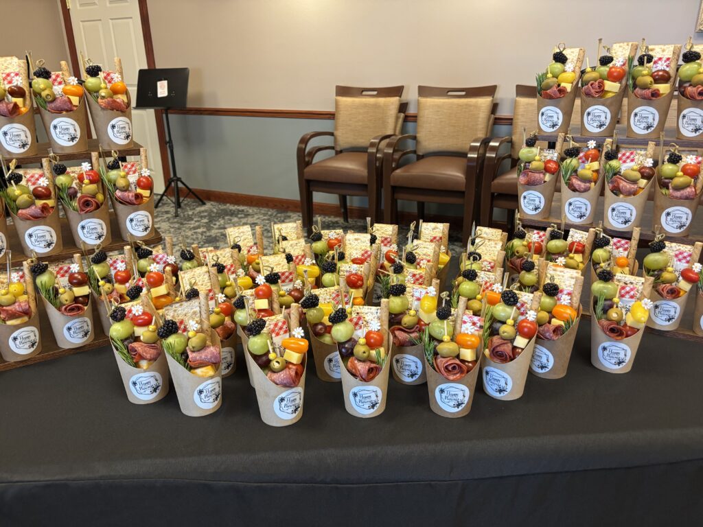 A display of mini charcuterie cups featuring meats, cheeses and various appetizers for a light snack.