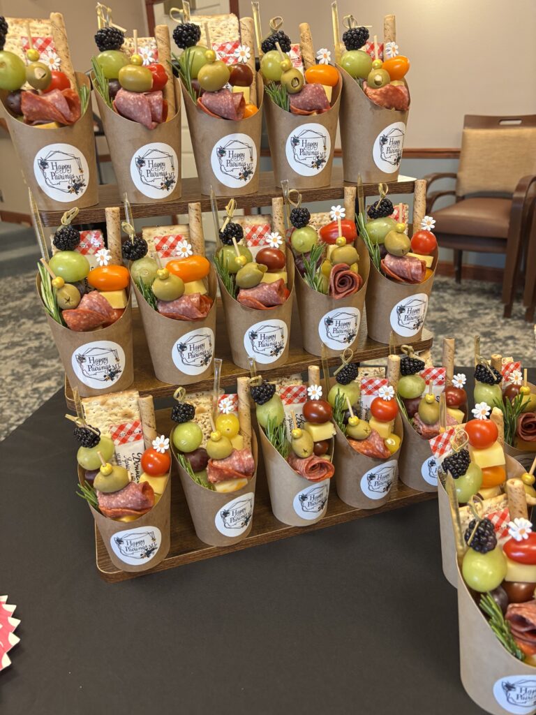 A display of mini charcuterie cups featuring meats, cheeses and various appetizers for a light snack.