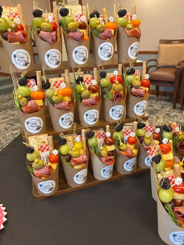 A display of mini charcuterie cups featuring meats, cheeses and various appetizers for a light snack.